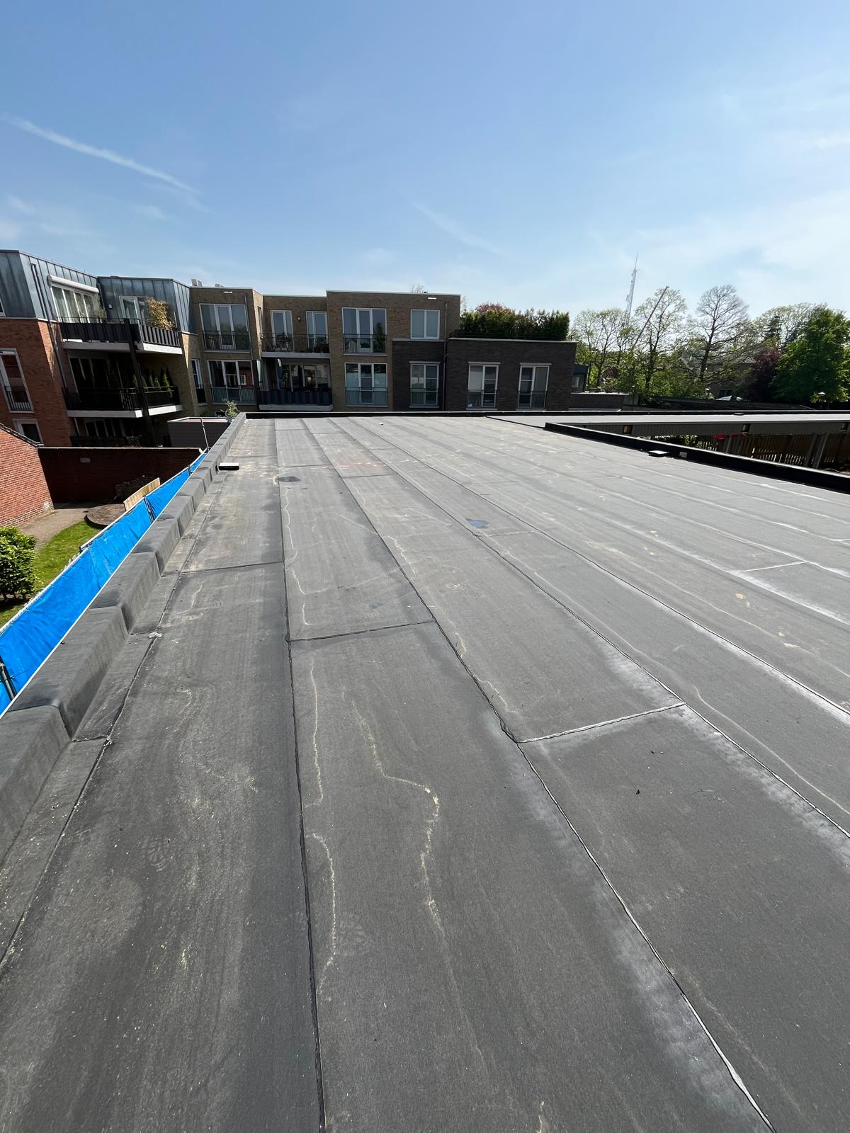 Strakke afwerking bitumen dakvlak appartementencomplex Zuidoost-Brabant